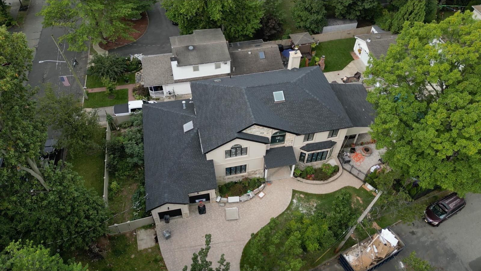 Estate roof overview with paver driveway and skylights