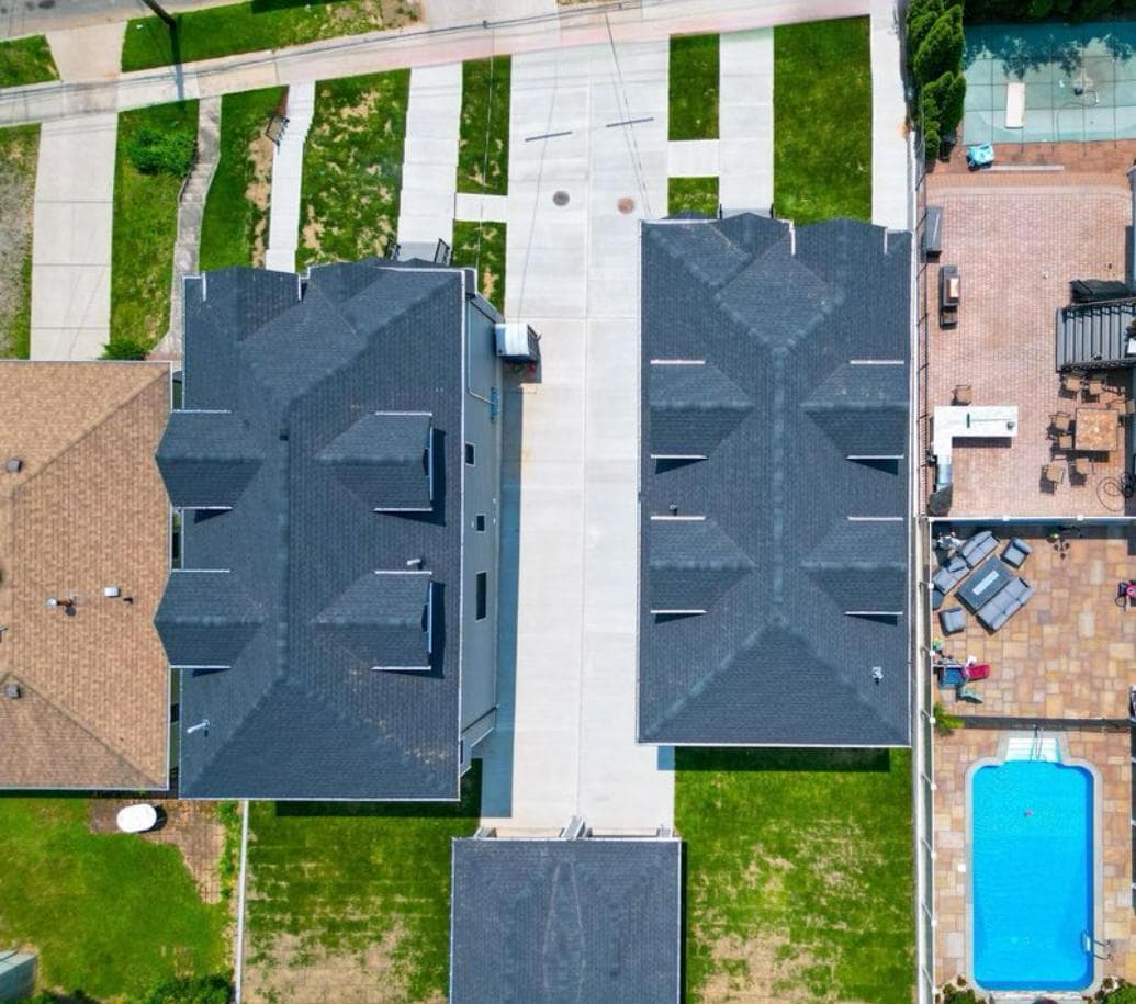 Top-down aerial of Staten Island duplex rooflines with dark shingles